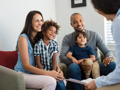 A mom, dad, brother and sister in a family counseling session with a therapist. 