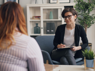 A therapist attentively listens to her client in an individual counseling session.
